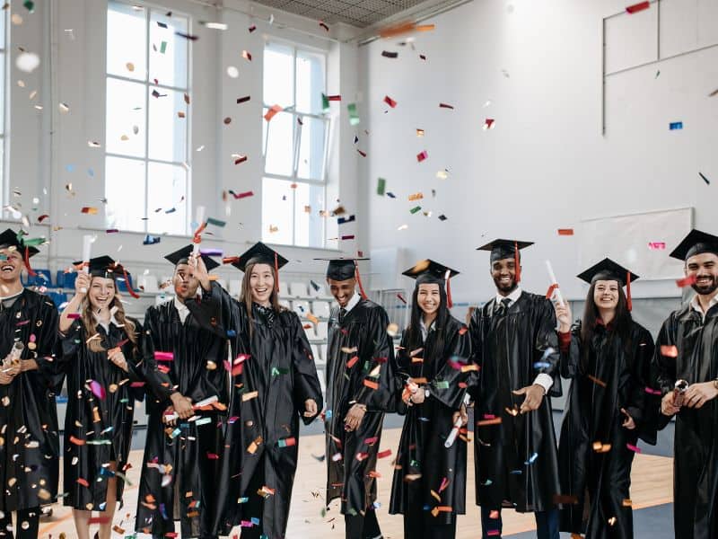 Graduates with their diplomas and confetti raining down