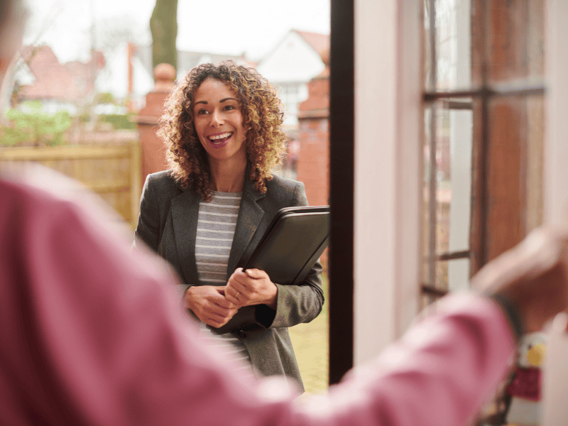 A social worker talking to a client at the door