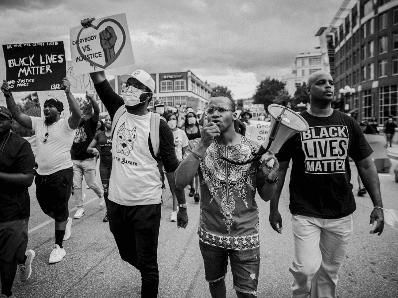 A group of people protesting and walking on a street